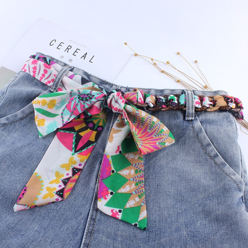 La ceinture foulard modèle WENDY, style hippie avec ses couleurs vert rose jaune bleu clair, ses anneaux autour de la ceinture, pour femme à porter sur un pantalon, chez Foulard Frenchy