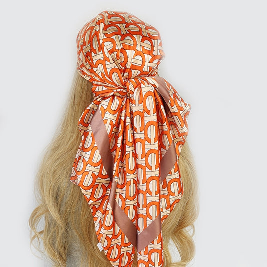 Le foulard cheveux femme Mélanie de couleur orange à motifs géométriques bronze
