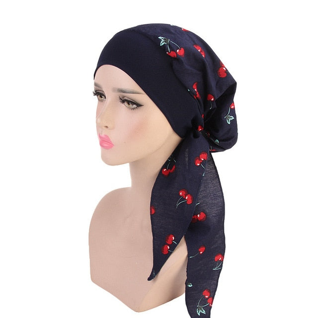 Femme portant le foulard cheveux chimio LUCIE style moderne décontracté couleur bleu marine à motifs Cerise de chez Foulard Frenchy