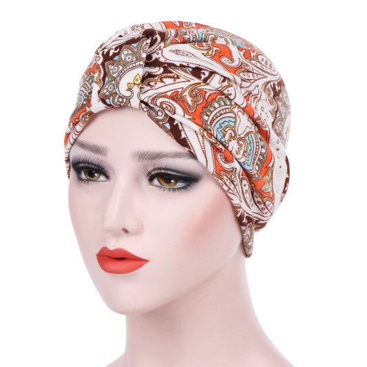 Femme portant le foulard chimio bonnet turban YZIL orange à motifs marron de chez foulard frenchy